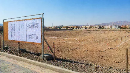 Empty UAE development plot at pre-mobilisation stage with ground markers and drawings pinned to a site board, representing the day one appointment point where independent PM delivers its highest value.